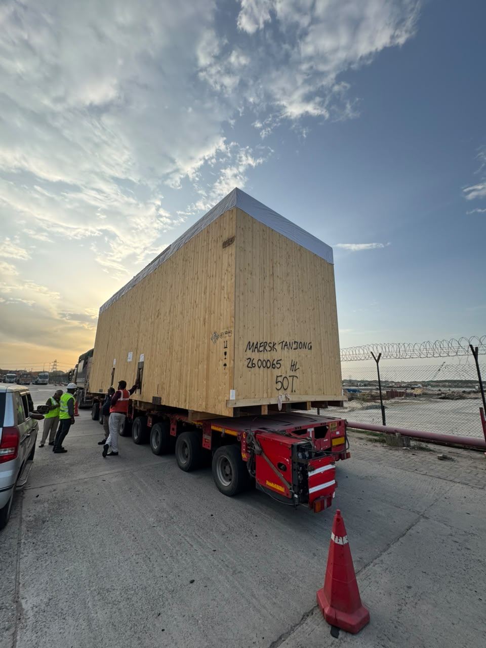 AREM team, port workers and a forklift operator coordinating around the packed cargo unit for customs examination