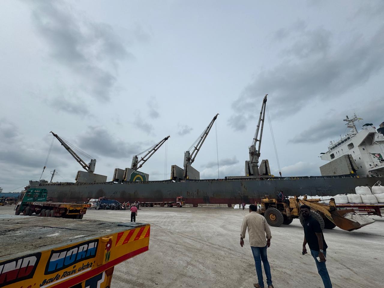 Wide view of the vessel at Chennai Port with cranes unloading breakbulk cargo onto waiting trailers